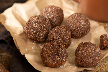 Chocolate coconuts. Chocolate balls with coconut. Chocolate candies or cookies with coconut, cinnamon and powdered sugar