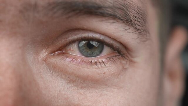 Close-up shot of crying man with tears in eye. Depressed male in despair cry sorrow. Teardrop on his face.