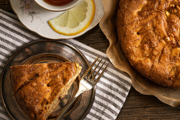 apple cake sliced with spoon and coffee jug