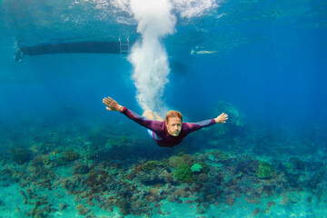 Active teenage man jump and dive underwater in tropical coral reef pool. Travel lifestyle, water sport, snorkeling adventure. Swimming lessons on summer sea beach vacation with kids