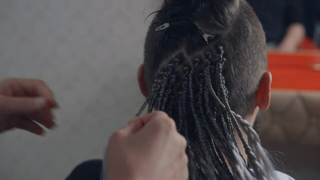 The master weaves afro braids on a&nbsp;man's&nbsp;hair