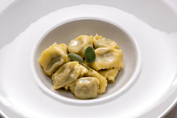 ravioli del plin typical Piedmontese filled pasta from the Langhe in Italy seasoned with butter and sage and parmesan.