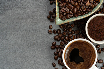 coffee beans and fresh brewed coffee in a cup on textured background