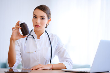 Woman doctor holding package with pills. Hospital worker with vitamins