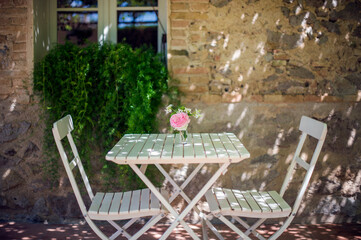 Romantic table and chair outdoor set up with old house background  