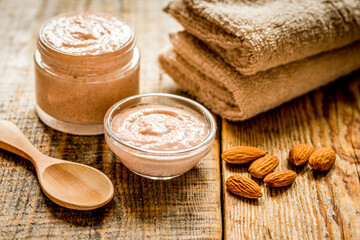 Fototapeta na wymiar body scrub with almonds for body care on wooden table background