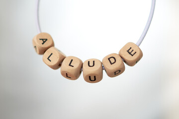 Word allude lined with wooden cubes