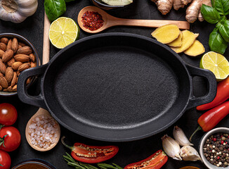 frying pan with vegetables and wooden spoon on wooden background
