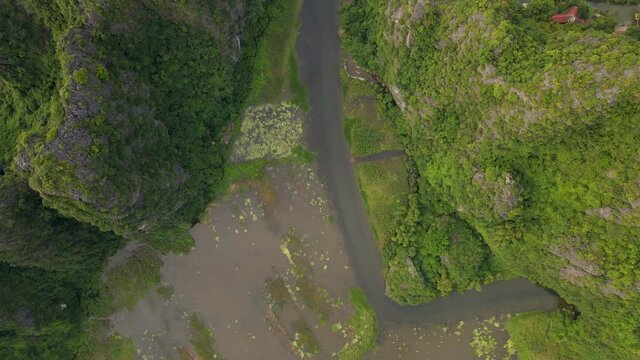 Aerial shot of beautiful limestone mountains with passes carved by a river in Ninh Binh region, a famous tourist destination in northern Vietnam. Travel to Vietnam concept