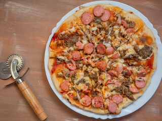 Homemade pizza with cheese, meat and sausages and cheese, with paprika