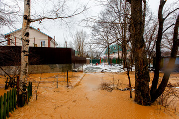 Ecological catastrophy. The stream of a dirty brown river flows along the ground in a holiday...
