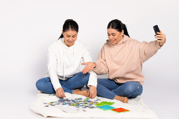 Pastime. The sisters put together a jigsaw puzzle on a white background and communicate via video communication.