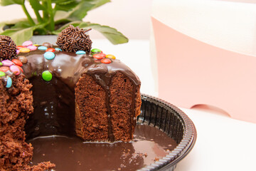 Chocolate cake with brigadeiro topping and colorful chocolate pieces..