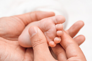 Baby feet in parent hands. Legs massage concept. Health care