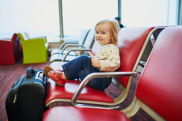 Adorable little toddler girl traveling by plane