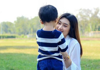 Asian mother and son happily in the park. Happy holiday life concept