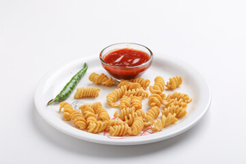 Past and potato chips with tomato sauce in plate. crispy and spicy snack on white background