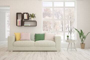 Fototapeta premium White living room with sofa and winter landscape in window. Scandinavian interior design. 3D illustration