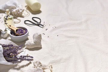 Hand made lavender sachets in textile bags and cotton hearts on cotton tablecloth, copy-space. Dry lavender flowers in tracing paper and lavender oil. Natural homemade gifts. Zero waste lifestyle.