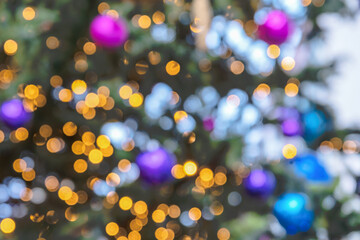 Fototapeta na wymiar Festive multicolor Christmas background. Christmas lights and Christmas tree decorations are out of focus