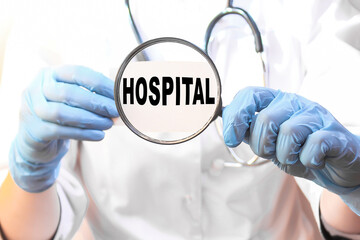 The doctor's blue - gloved hands show the word HOSPITAL - . a gloved hand on a white background. Medical concept. the medicine