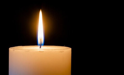 burning candle on black background