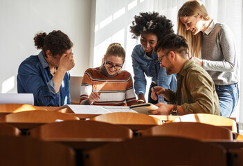 	
Group of design students in the classroom.They examining blueprint.	
