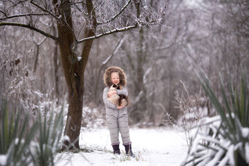 Girl with cat in winter in the garden