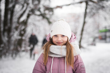 Beautiful little girl five years old portrait in a snowy city park