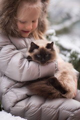Fototapeta na wymiar Girl with cat in winter in the garden