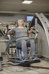 Fototapeta na wymiar Fat woman dieting, fitness. Portrait of obese woman working out in gym.