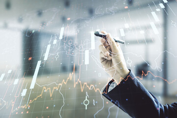 Double exposure of man hand with pen working with abstract creative financial diagram and world map on blurred office background, banking and accounting concept