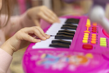 Small hands of a child playing the piano. Children play music.
