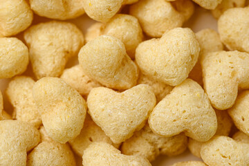 Macro photo of dry breakfast made of wheat or oats in the heart shape. Food background of breakfast cereals clouse up