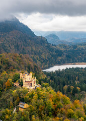 A view of Bavarian Alps, storm sky, lake and Hohenschwangau castle dating from the 12th century near Fuessen town in Bavaria, Germany in autumn