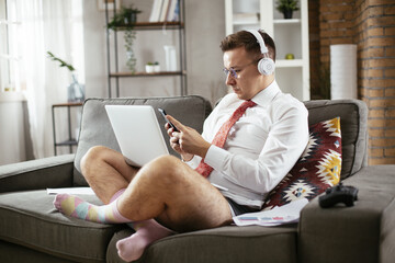 Businessman with no pants working at home. Young man using the laptop having video call.
