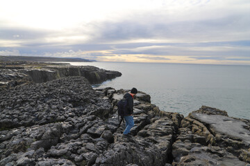 Backpacker walking nearby the coastline of Ireland