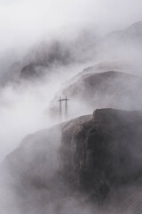 Fototapeta premium Strommast in den Bergen mit Nebel