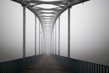 pedestrian bridge of the city in the early fog