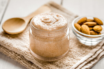 cosmetic for women with almond scrub on desk background