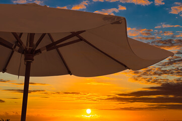 Parasol de plage sur soleil couchant 