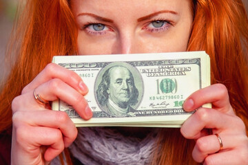 Close up portrait of happy beautiful woman with US Dollar bill as symbol: money is the best motivation for the people.