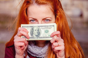 Portrait of happy beautiful woman with US Dollar bill as symbol: money is the best motivation for the people.