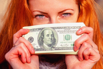 Close up happy beautiful woman with US Dollar bill as symbol: money is the best motivation for the people.