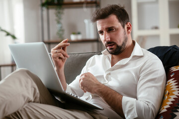 Young businessman working with laptop at office. Businessman sitting on sofa working on laptop computer..