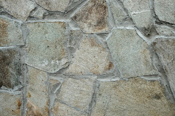 Wall texture of natural chipped stone with cement joints. Decorative stone background. Cobblestone pavement close up.