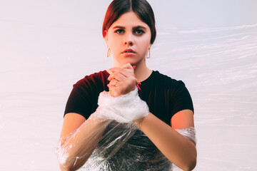 Human trafficking. Female slavery. Forced labour. Art portrait of insecure victim woman with tied...