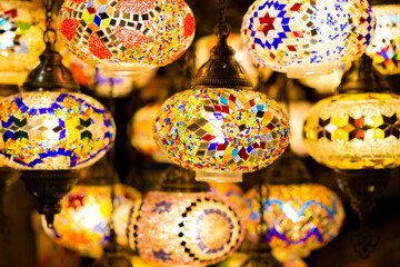 Fototapeta na wymiar Traditional handmade multicolor Turkish, Moroccan, Arabian lamps hanging with nice blurred background. Mosaic style and colored glass lantern. Suitable for Ramadan Kareem greeting.