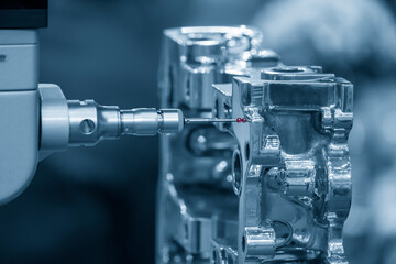 The  multi-axis CMM machine checking the aluminum cylinder block parts . The quality control of automotive parts with multi axis CMM machine.