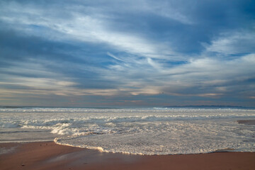 Scenic seascape. Empty sand beach and dramatic cloudy sky on background